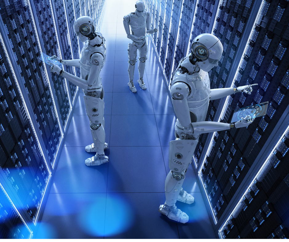 A high-angle shot shows three white humanoid robots working in a dark server room. The robots are surrounded by tall, glowing blue server racks on both sides. Two robots in the foreground are positioned on opposite sides of a central walkway, leaning over and looking at transparent blue tablets in their hands. The robot in the background stands in the middle of the aisle, looking forward.