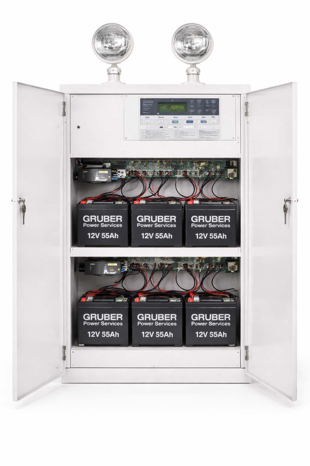 Emergency Lighting Power Cabinet โ Batteries & DC Plant Large emergency lighting power cabinet with doors open showing internal battery shelves and control electronics